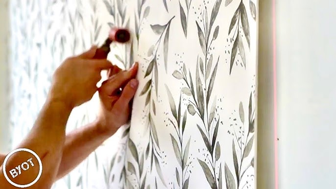 Professional wallpaper installer at work